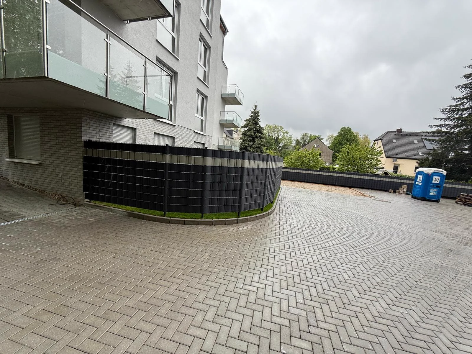 Fertiggestellter Parkplatz mit Sichtschutzzaun Duisburg – GaLaBau Brüder Berisha